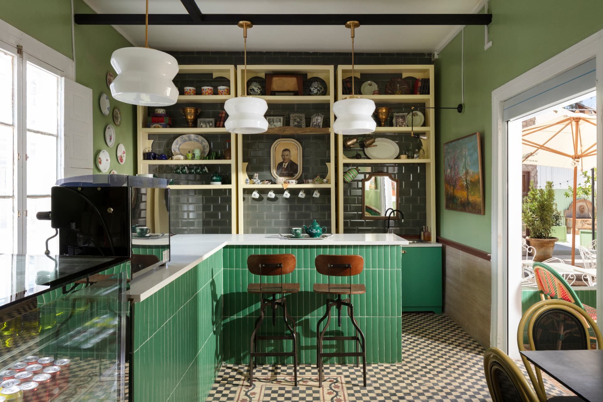 Barra principal de Caffè La Nonna con azulejos verdes y vista a la terraza