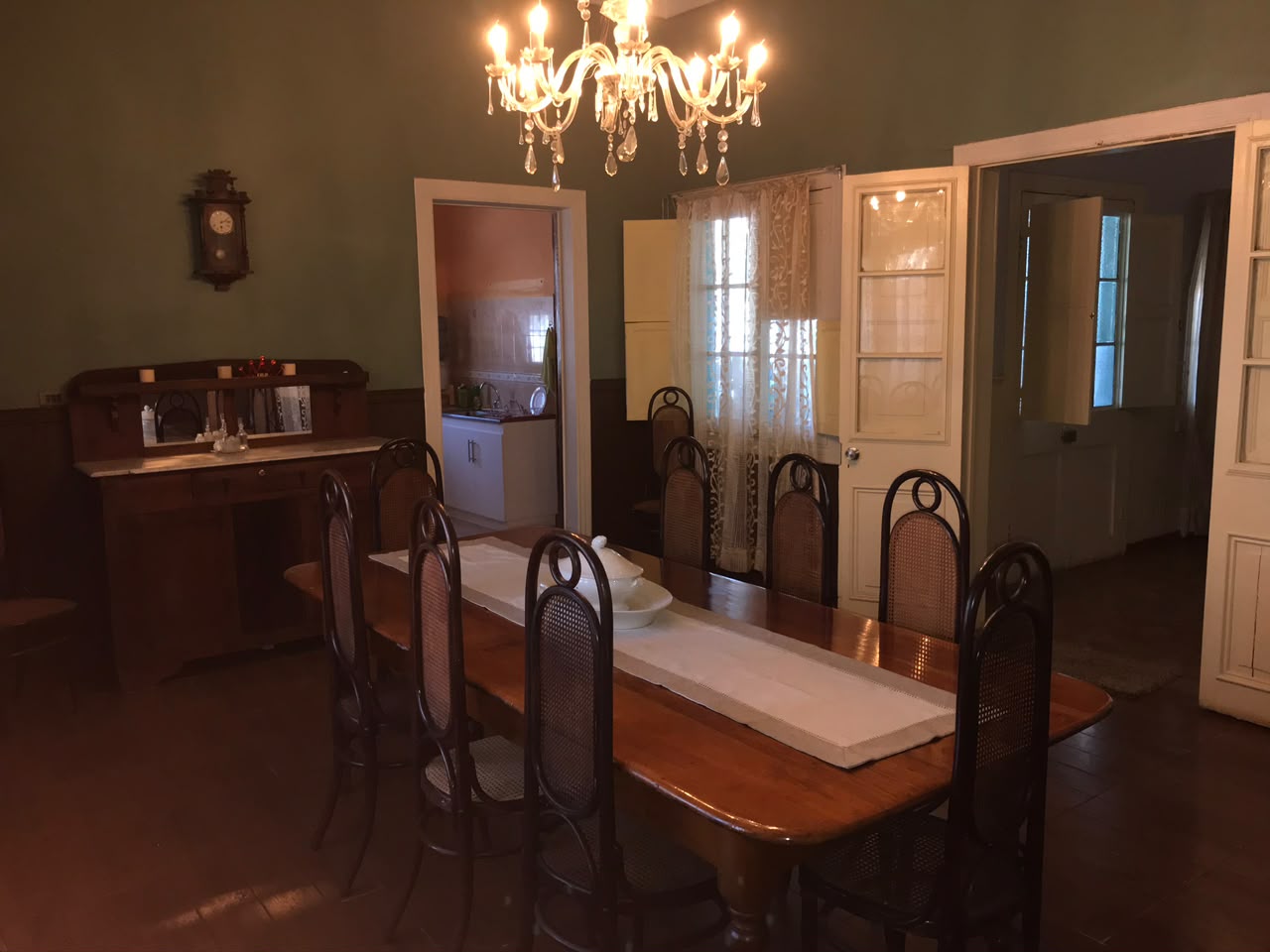 Comedor familiar de Casa Vallereggia con mesa larga y lámpara de cristal