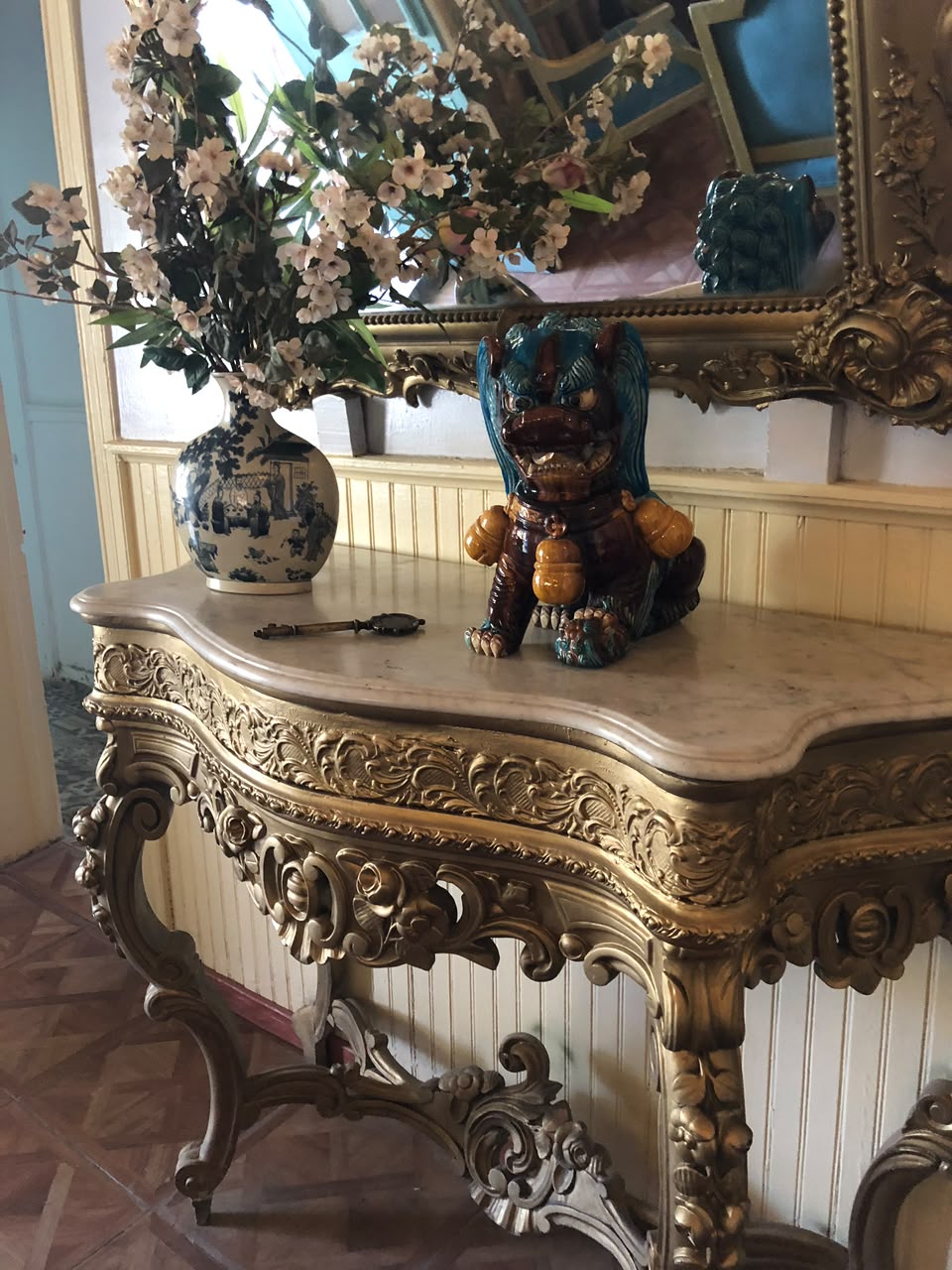 Consola dorada con figuras orientales, flores y espejo de Casa Vallereggia