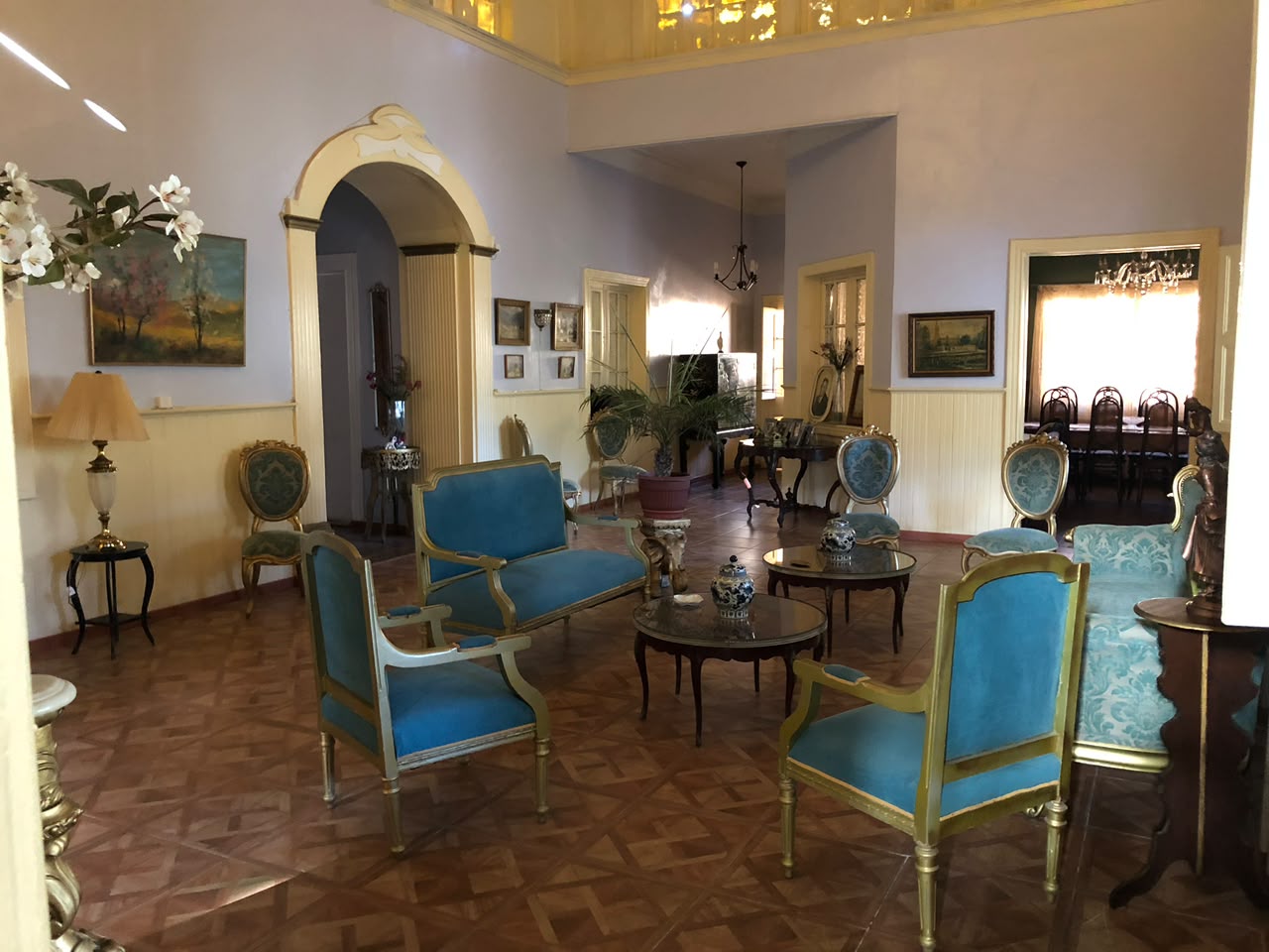 Gran salón histórico de Casa Vallereggia con mobiliario azul y arcos interiores