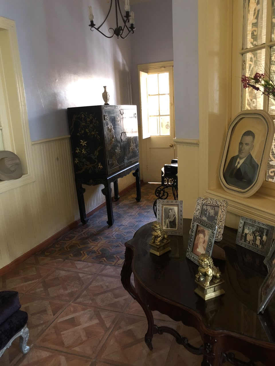 Pasillo de Casa Vallereggia con consola oriental y retratos familiares